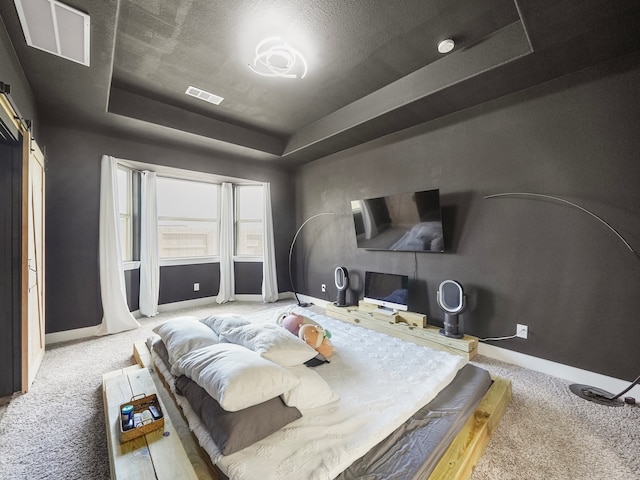 bedroom featuring a raised ceiling and light colored carpet