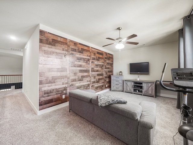 living room with wooden walls, carpet floors, and ceiling fan