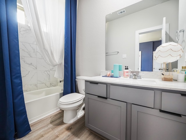 full bathroom featuring hardwood / wood-style flooring, toilet, vanity, and shower / tub combo with curtain