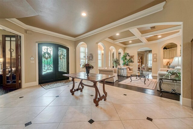 tiled foyer entrance featuring beam ceiling, french doors, coffered ceiling, and ornamental molding