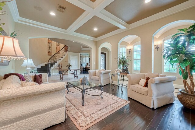 living room with dark wood-type flooring, beam ceiling, ornamental molding, and coffered ceiling