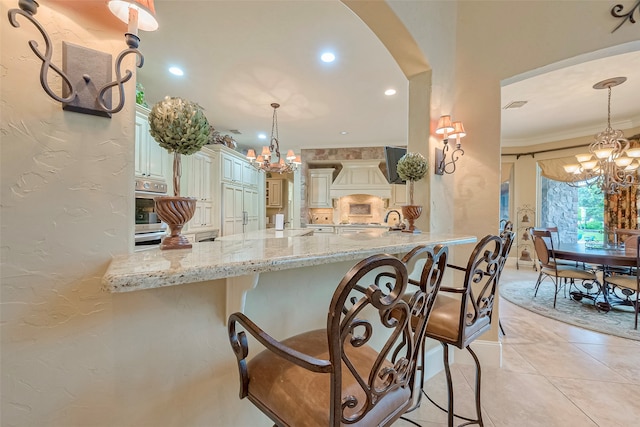 kitchen with hanging light fixtures, ornamental molding, and a chandelier