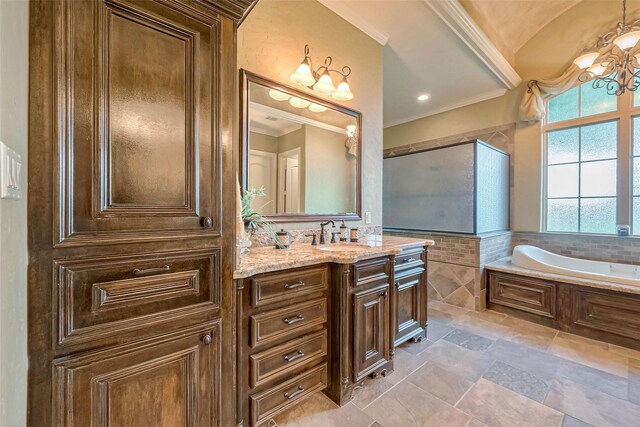 bathroom featuring tile patterned flooring, crown molding, a chandelier, vanity, and tiled tub