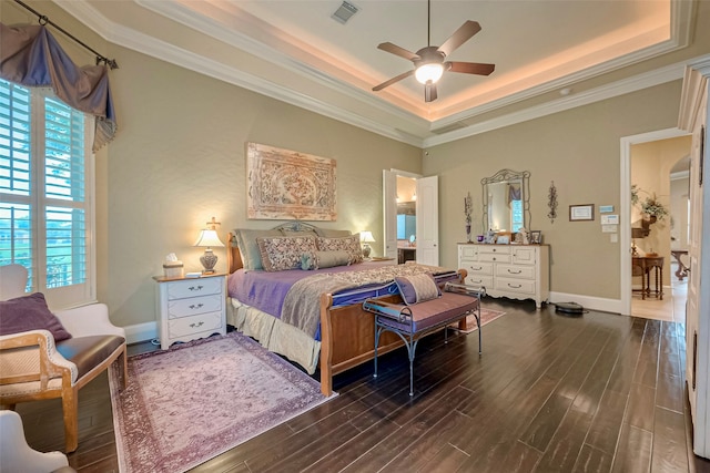 bedroom with dark wood-type flooring, a raised ceiling, ornamental molding, and ceiling fan