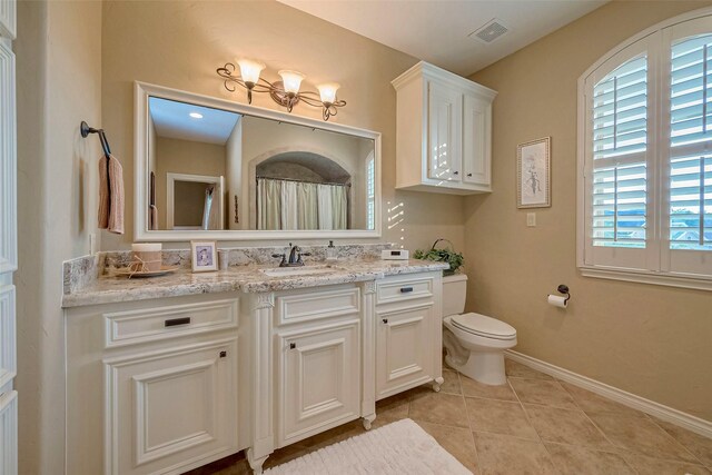 bathroom featuring vanity, tile patterned flooring, and toilet