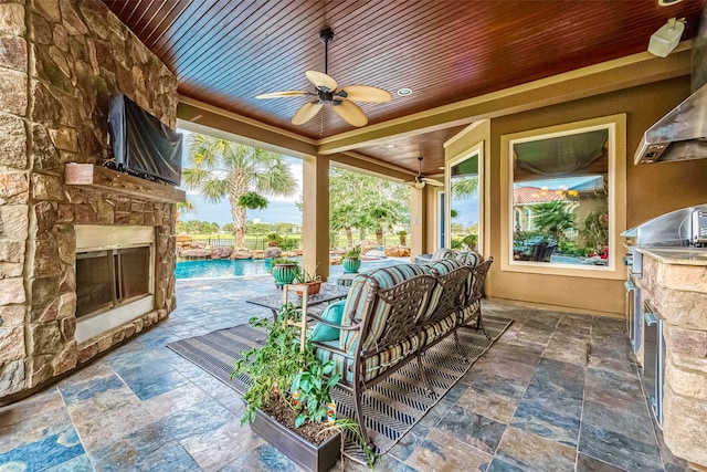 view of patio with an outdoor living space with a fireplace, ceiling fan, and area for grilling