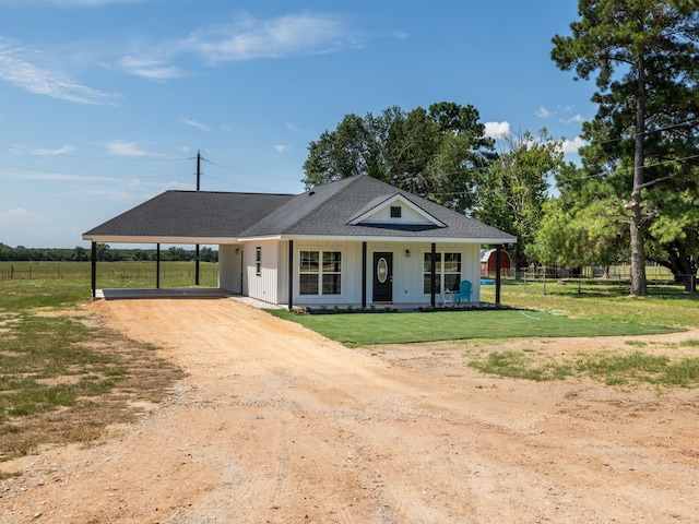 view of front facade with a carport, a porch, and a front yard