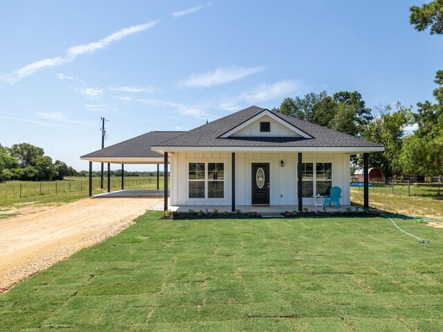 view of front of property with a carport, covered porch, and a front yard