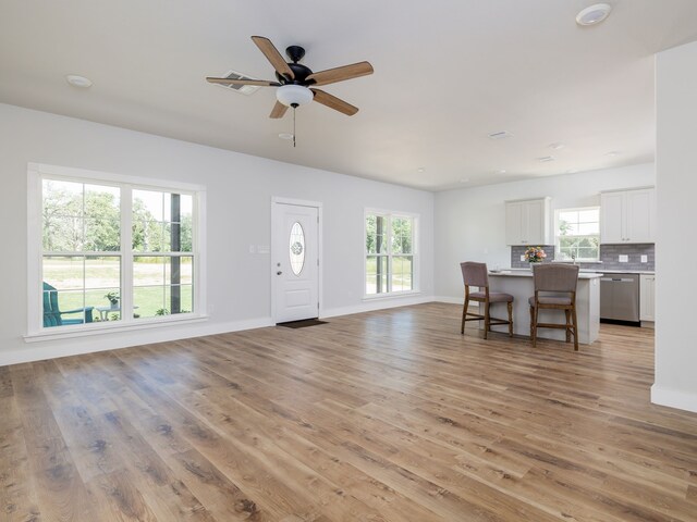 living room featuring light hardwood / wood-style floors, a healthy amount of sunlight, and ceiling fan