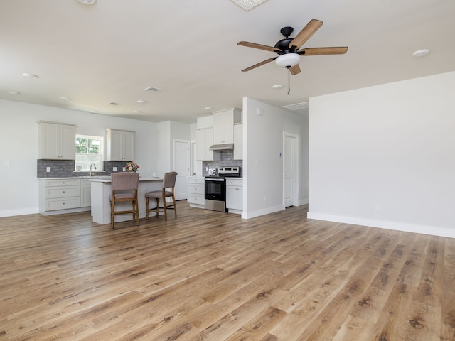 living room with sink, ceiling fan, and light wood-type flooring