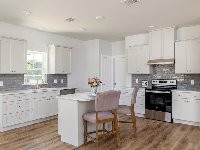kitchen with sink, white cabinetry, a center island, stainless steel electric range oven, and dark hardwood / wood-style flooring