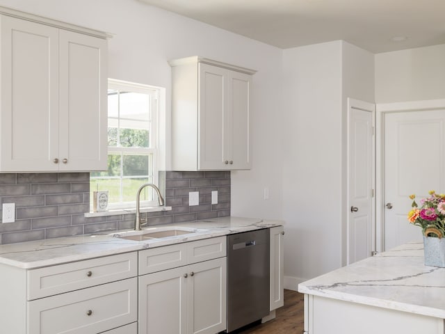 kitchen featuring dishwasher, sink, and white cabinets