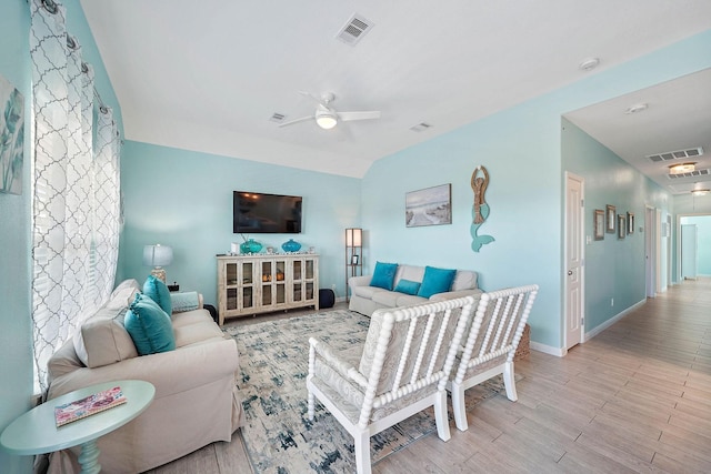 living room featuring lofted ceiling, light hardwood / wood-style flooring, and ceiling fan