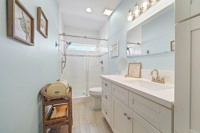 bathroom featuring vanity, an enclosed shower, and toilet