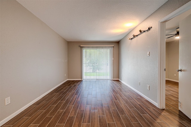 empty room featuring ceiling fan, dark hardwood / wood-style flooring, and a textured ceiling