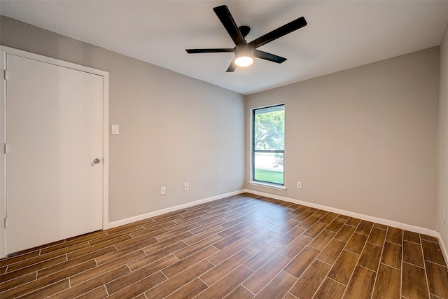 empty room with dark hardwood / wood-style flooring and ceiling fan