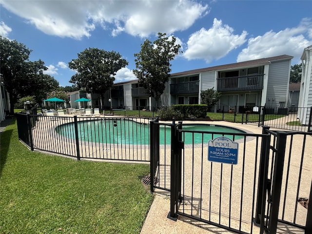 view of swimming pool with a lawn