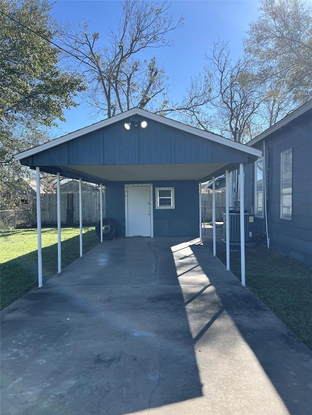 exterior space with a lawn, cooling unit, and a carport