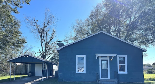 view of front of property with a carport, driveway, and fence