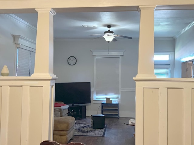 living room featuring dark hardwood / wood-style floors, ceiling fan, crown molding, and decorative columns