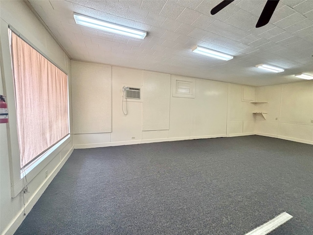 basement featuring dark colored carpet and ceiling fan