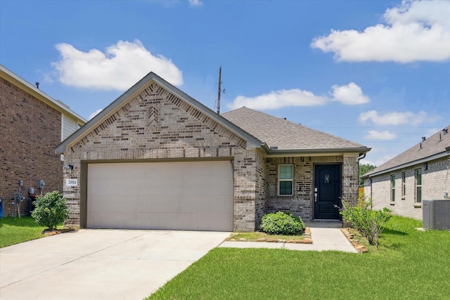 view of front of house featuring cooling unit, a garage, and a front lawn