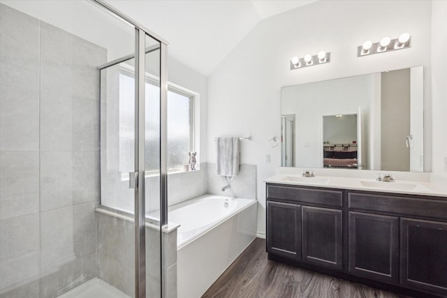 bathroom featuring lofted ceiling, independent shower and bath, hardwood / wood-style floors, and vanity