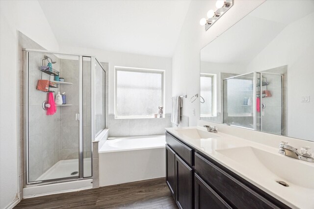 bathroom featuring hardwood / wood-style flooring, lofted ceiling, plus walk in shower, and vanity