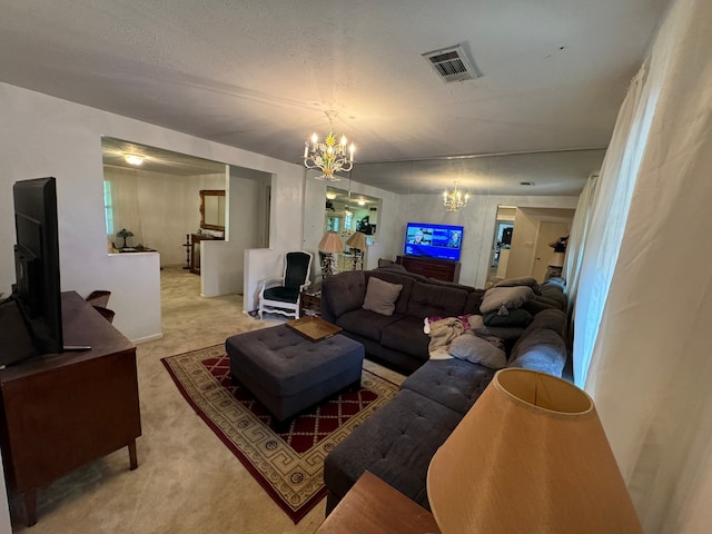 living room with a textured ceiling, an inviting chandelier, and light carpet