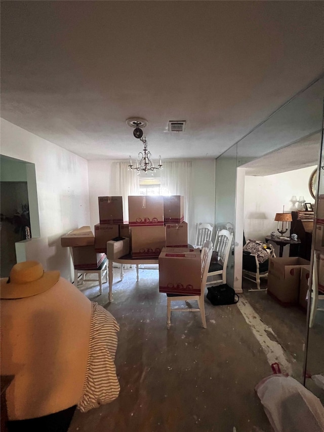 living room with a notable chandelier and concrete flooring