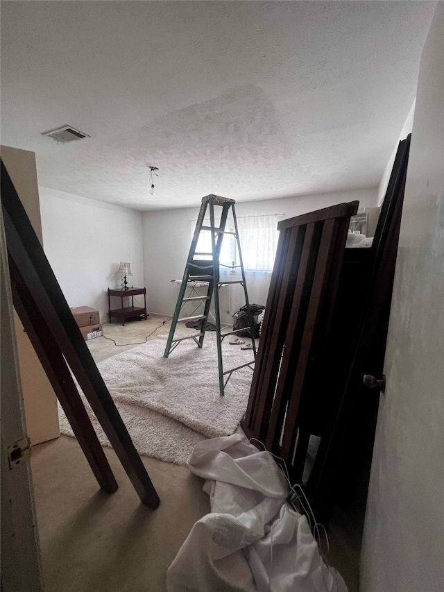 bedroom with a textured ceiling and carpet floors