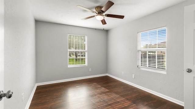 spare room with dark wood-type flooring, ceiling fan, and a wealth of natural light