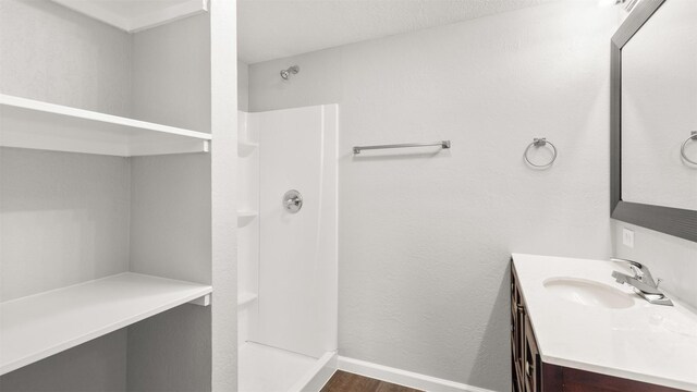 bathroom with vanity, wood-type flooring, and walk in shower