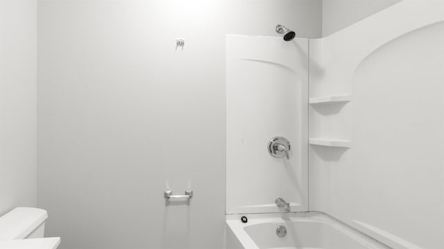 bathroom featuring shower / bathing tub combination and toilet