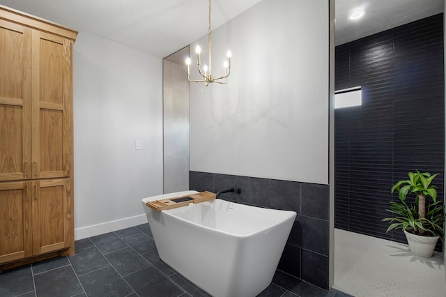 bathroom with tile walls, shower with separate bathtub, an inviting chandelier, and tile patterned flooring