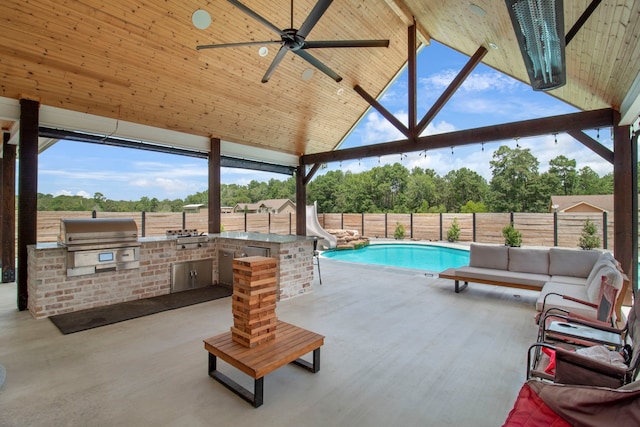 view of swimming pool with an outdoor kitchen, a patio, area for grilling, and a water slide