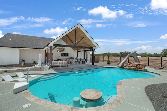 view of pool with an outdoor hangout area, a patio area, and a water slide