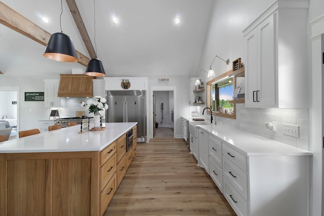 kitchen with decorative backsplash, white cabinetry, and pendant lighting