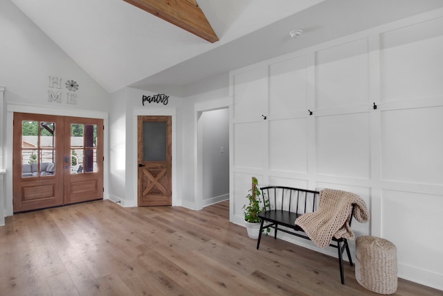 entryway featuring light wood-type flooring, beam ceiling, french doors, and high vaulted ceiling