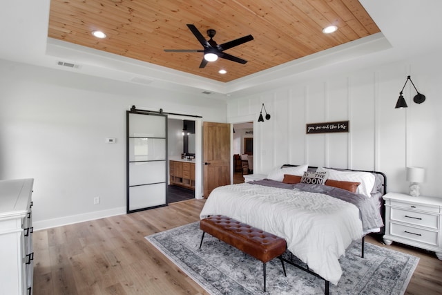 bedroom featuring wooden ceiling, a tray ceiling, and ceiling fan