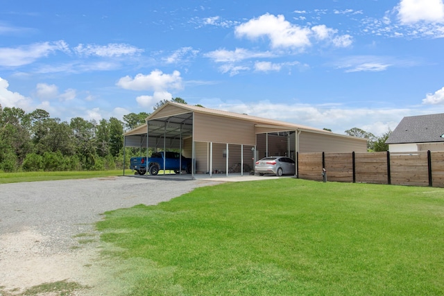 rear view of house featuring a carport and a yard