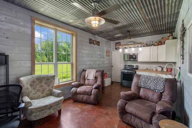 living room featuring ceiling fan, concrete floors, a healthy amount of sunlight, and sink