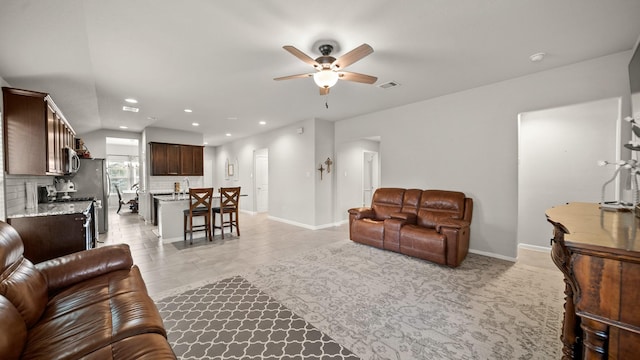 tiled living room with ceiling fan