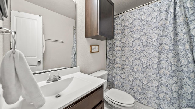 bathroom with vanity, a textured ceiling, and toilet