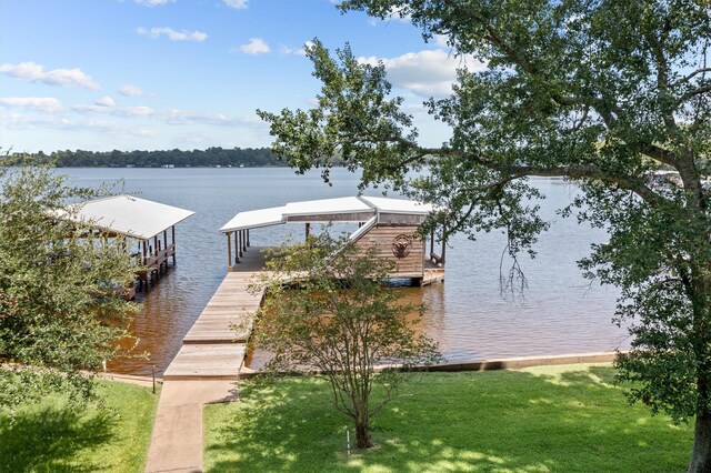 dock area with a yard and a water view