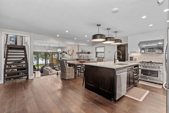 kitchen with stainless steel appliances, decorative light fixtures, dark hardwood / wood-style flooring, and sink