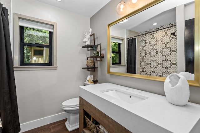 bathroom featuring hardwood / wood-style floors, toilet, a wealth of natural light, and vanity