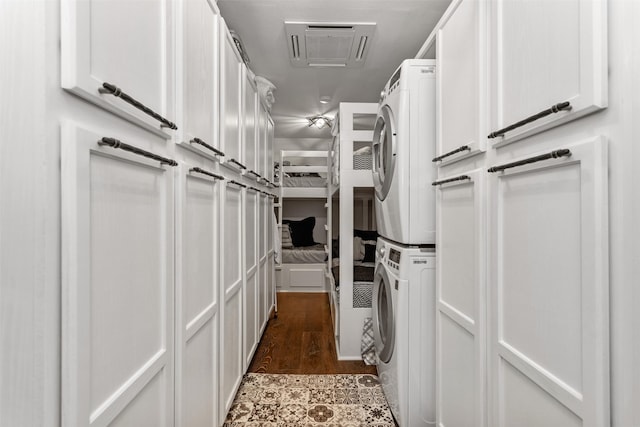 spacious closet with stacked washer and clothes dryer and light hardwood / wood-style flooring