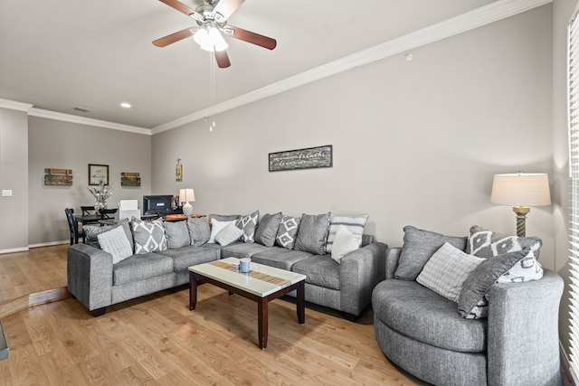 living room featuring light hardwood / wood-style flooring, ceiling fan, and crown molding