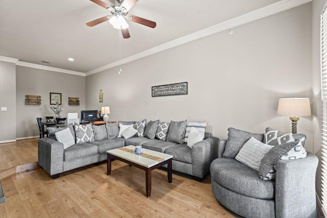 living room featuring crown molding, ceiling fan, and light wood-type flooring